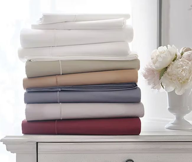 A stack of sheets in various colors neatly arranged in a pile.