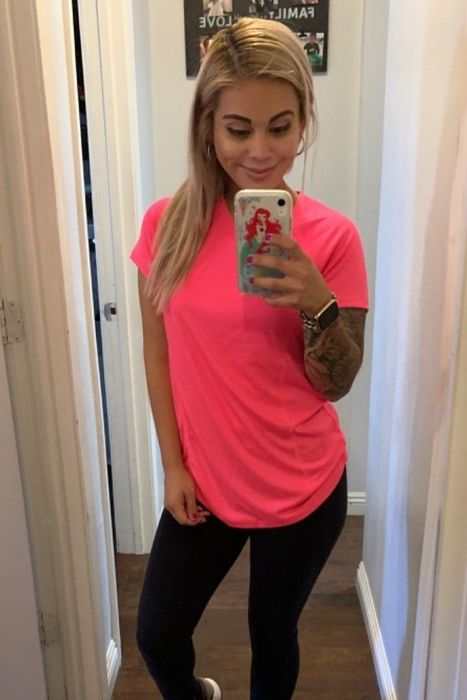 A reviewer wearing the tee in hot pink.
