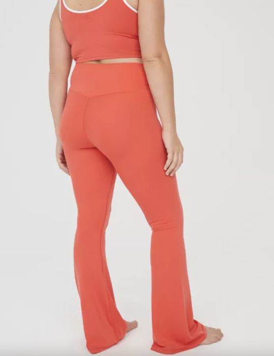 A person in a red tank top and flared leggings, details obscured. Identity unknown.