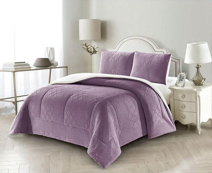 A purple comforter paired with matching sham pillows, featuring a textured design.