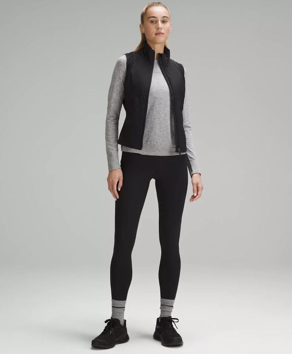 model wearing a black vest open over a grey longsleeve