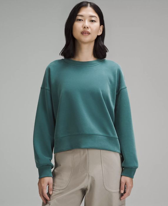 model wearing teal sweatshirt with cargo pants