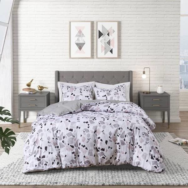 This terrazzo print comforter adds a unique and vibrant touch to any bedroom.