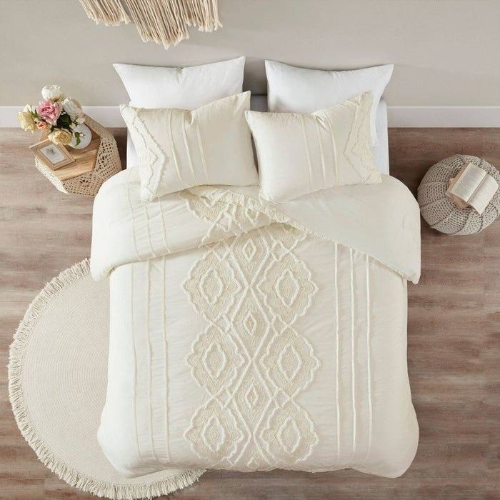 A white comforter with matching sham pillows, featuring a vertical textured arabesque pattern.