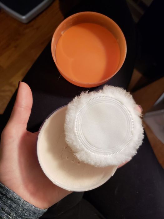 The loose powder and its applicator puff resting in someone's hand