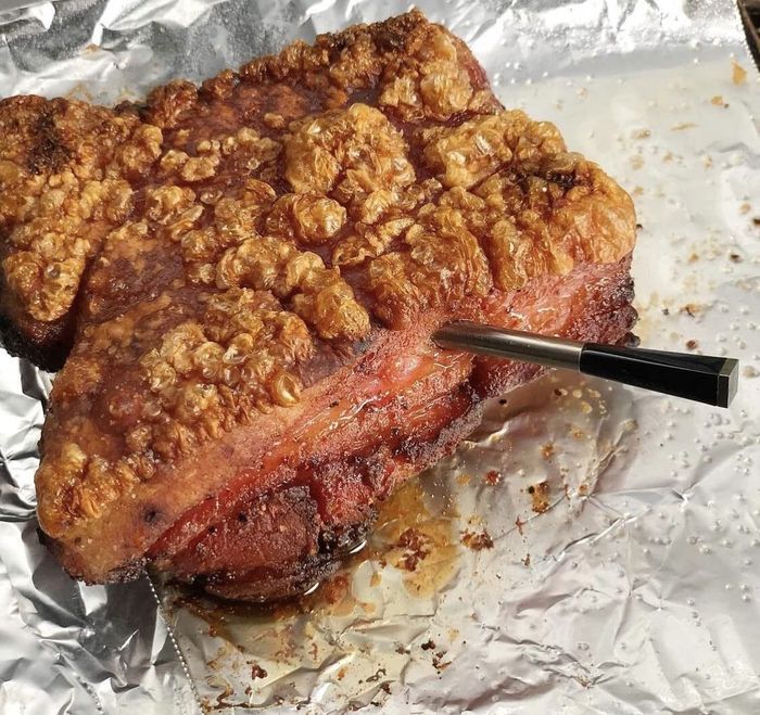 A smart meat thermometer inserted into a piece of pork.
