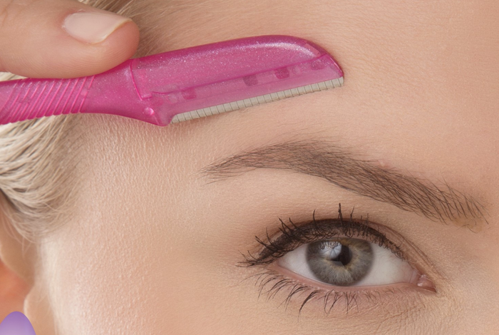 A model demonstrating the use of a tool to remove hair above the eyebrow