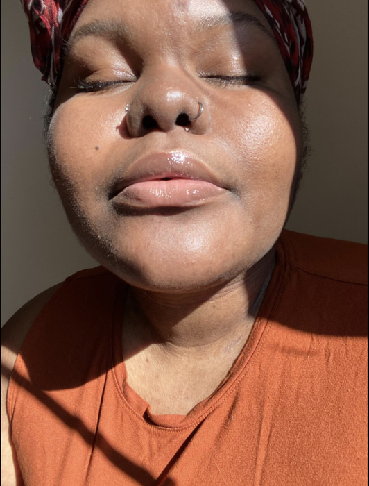 A reviewer showcasing the lip gloss on their lips