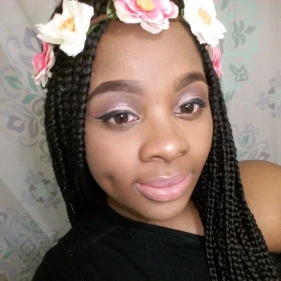 A person adorned with a flower crown, showcasing a beautiful nude eyeshadow look.