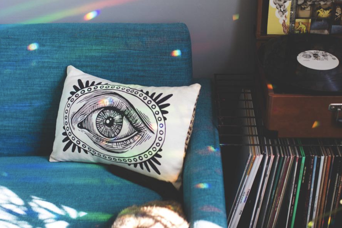 a reviewer's snapshot showing tiny rainbows casting colorful reflections across a couch and room