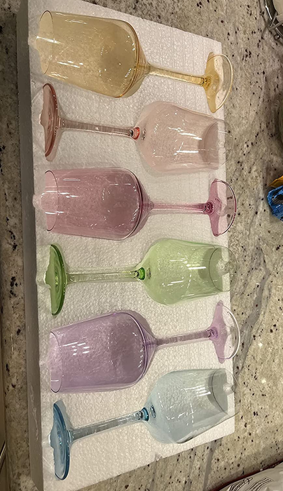 a reviewer's photo showcasing a set of six wine glasses, each in a different vibrant color