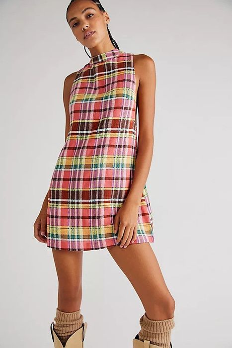 The model showcases the dress, highlighting its fit and design.