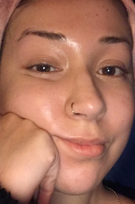 A person resting their chin on their hand, offering a subtle smile to the camera