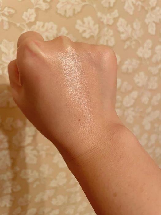 A swatch of the balm applied to the back of a hand, showcasing its hydrating and dewy finish