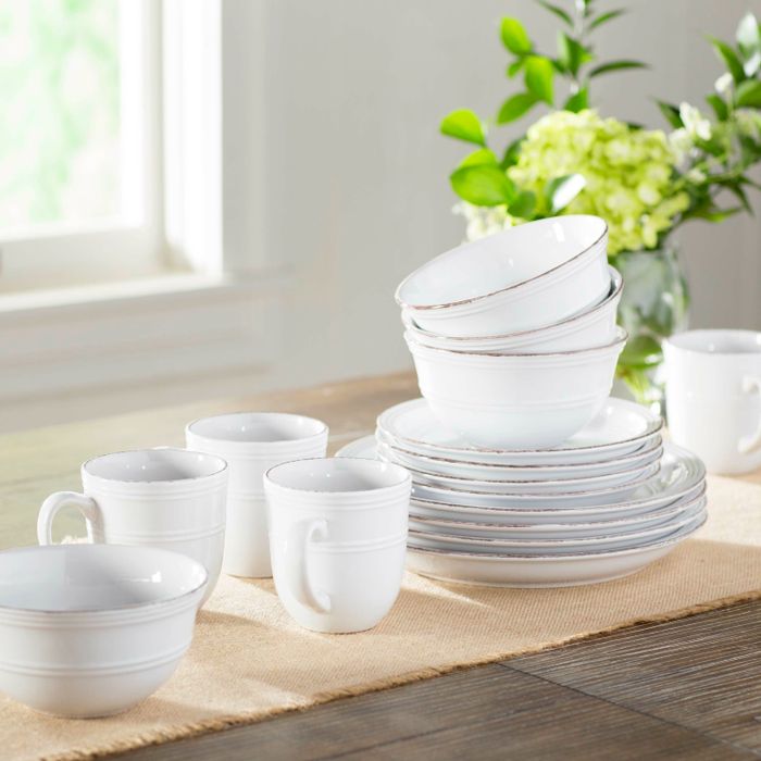 The white dinnerware set featuring distressed trim, elegantly displayed on a table