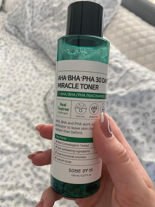 A reviewer holding the toner bottle