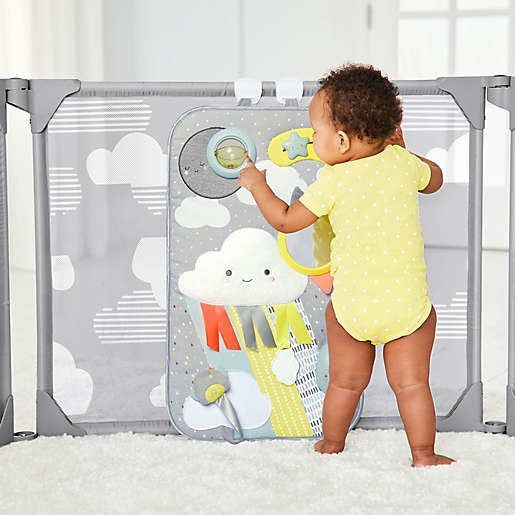 a baby happily engaging with the toy inside the playpen