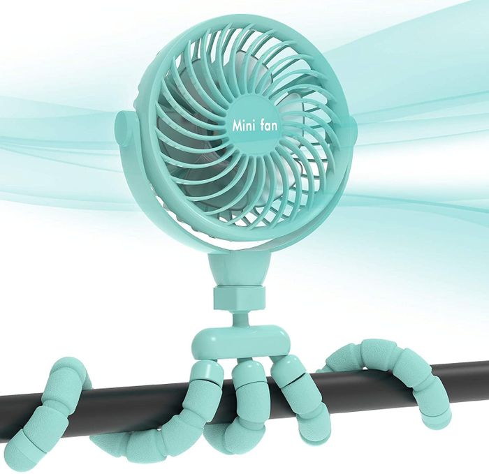 a light blue fan with a tripod wrapped around a bar