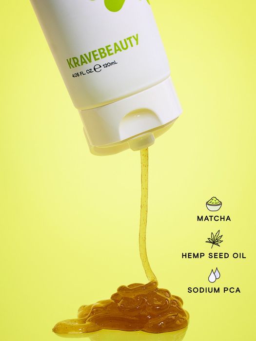 A KraveBeauty product bottle dispensing a gel-like cleanser, with labels emphasizing key components: Matcha, Hemp Seed Oil, and Sodium PCA
