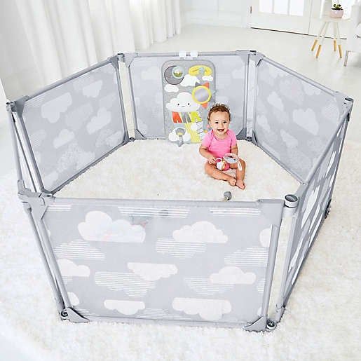 a gray playpen with cloud patterns and a cloud-themed toy inside
