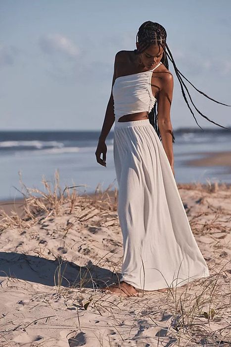 The model is wearing the off-white dress, showcasing its elegant and timeless design.