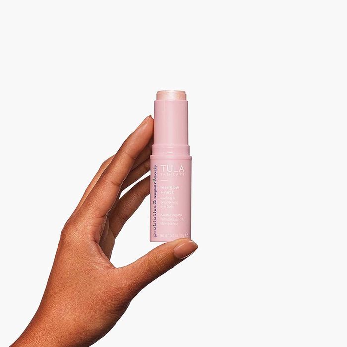 Model holding the pink eye balm stick
