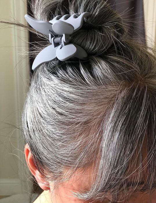A close-up shot of a person’s hair styled in a bun, secured with a large hair clip