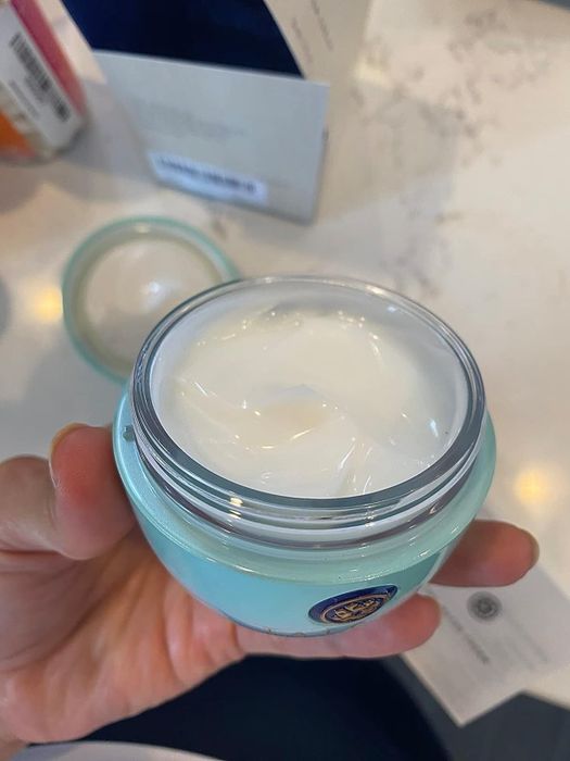 A reviewer is seen holding an open container