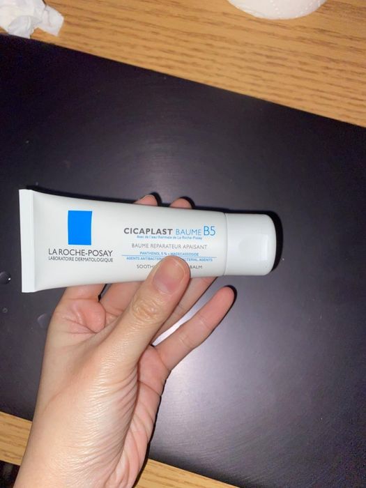 A reviewer is pictured holding the cream