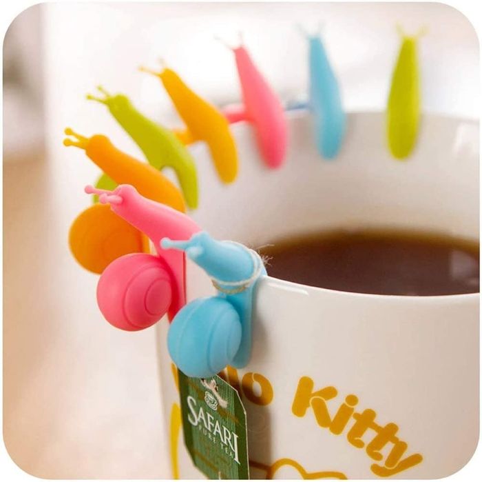 A lineup of colorful snails sitting on the rim of a mug