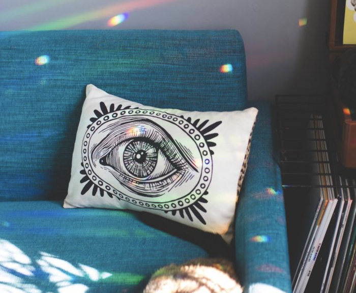 A reviewer’s photo showing tiny rainbows reflected across a couch and the surrounding room