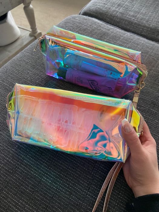 A reviewer holding the makeup bags filled with various items