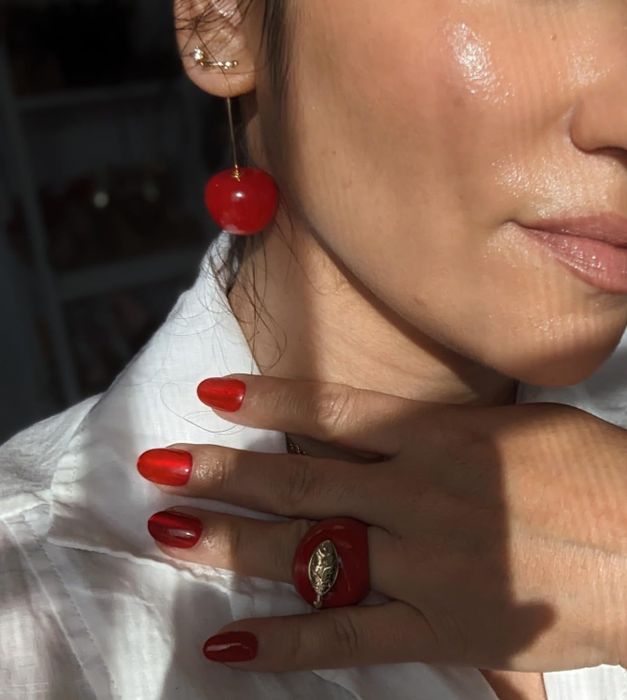 The reviewer is seen wearing the cherry earrings.