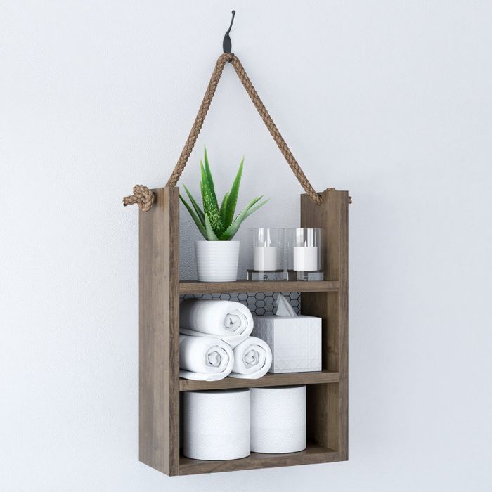 Photo of a hanging shelf neatly holding toilet paper, a tissue box, plants, and hand towels
