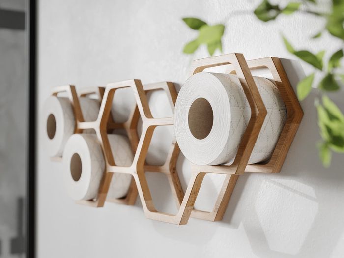 A honeycomb-shaped organizer filled to the brim with toilet paper rolls