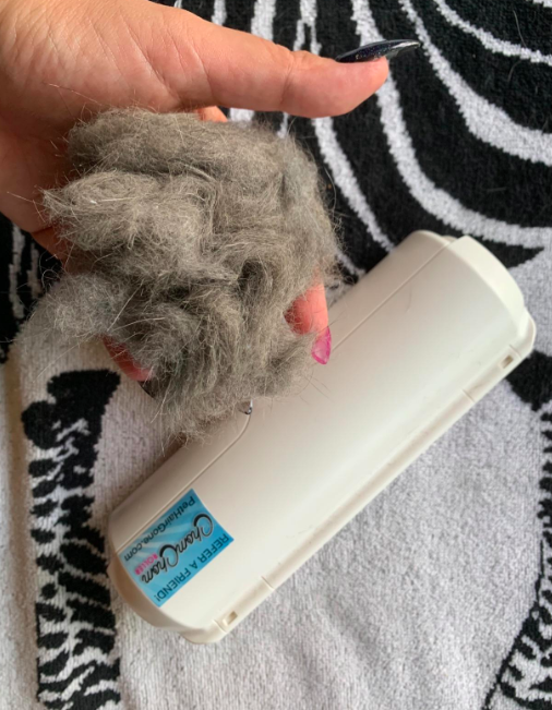 A reviewer displaying a bundle of dog fur after using the roller