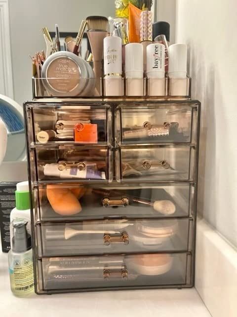 A reviewer's bronze acrylic makeup organizer, fully stocked with various beauty products