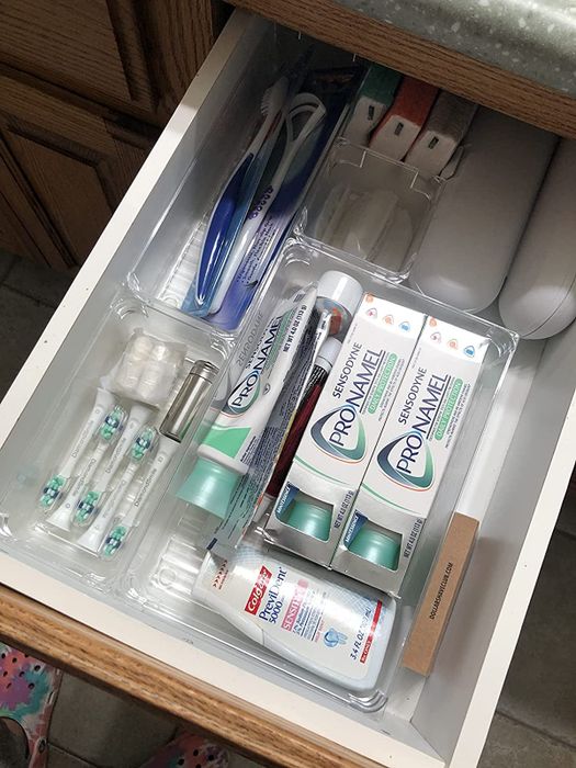 A reviewer’s photo showcases drawer organizers neatly holding oral hygiene products.