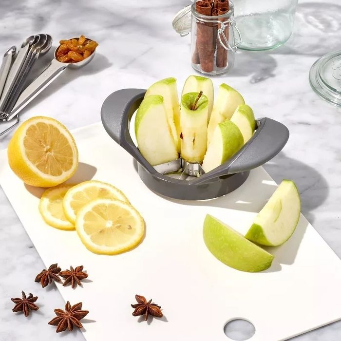 A kitchen counter displaying a sliced lemon, an apple slicer with cut apples, and spices like star anise — perfect for the home cook
