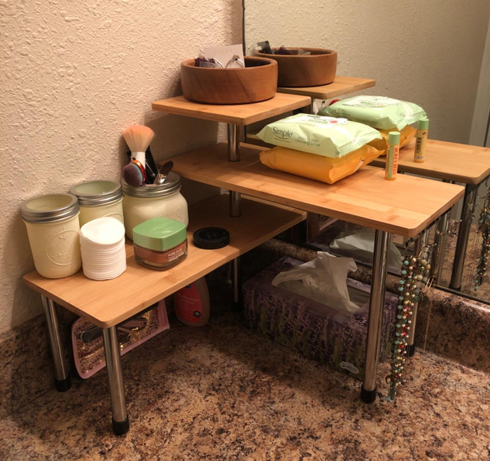 A different reviewer's multi-tiered corner shelf placed on the bathroom counter, neatly holding an assortment of items