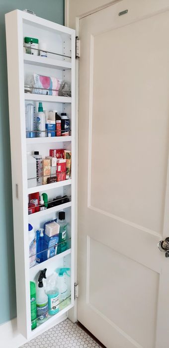 The same reviewer demonstrates the cabinet opened, showcasing numerous shelves packed with various bathroom essentials