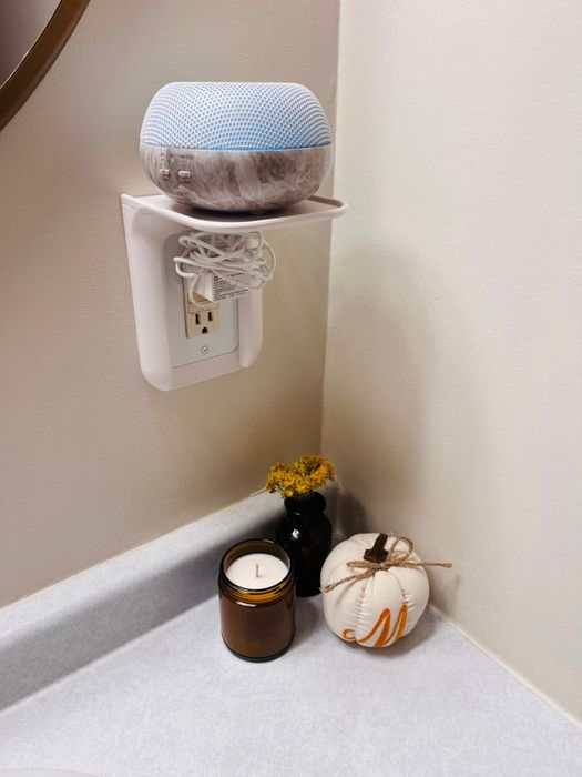 Another reviewer's photo of a white outlet shelf supporting a diffuser
