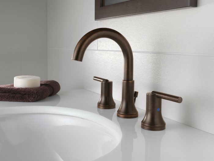 A bronze faucet installed on a bathroom sink