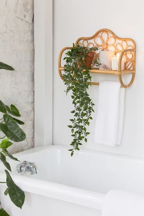 A boho-style rattan shelf elegantly hung above a bathtub