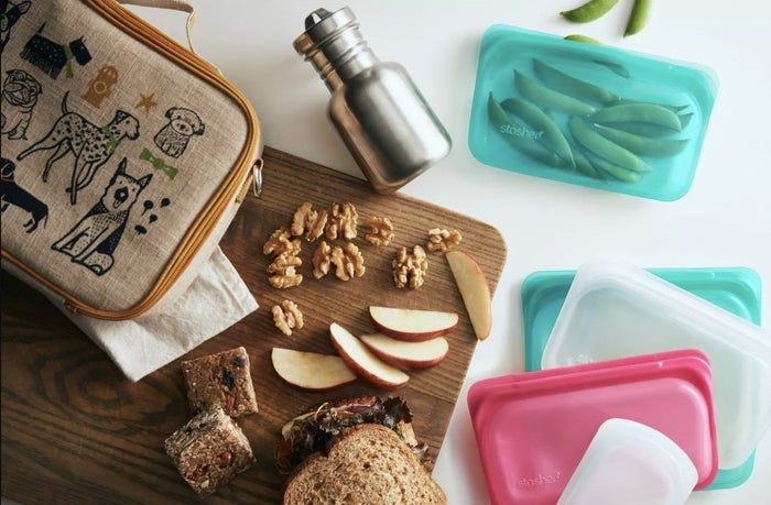 A cutting board filled with snacks, accompanied by Stasher bags