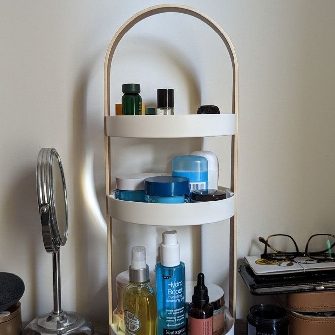 A three-tiered storage unit filled with an assortment of skincare essentials