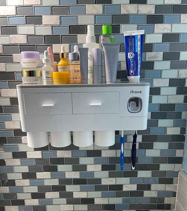 A reviewer’s photo shows the white caddy mounted on a bathroom wall, neatly organizing various toiletries.