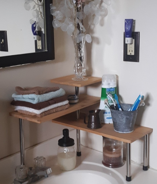 The reviewer's corner rack in the bathroom neatly organizes hand towels, toothbrushes, and deodorant