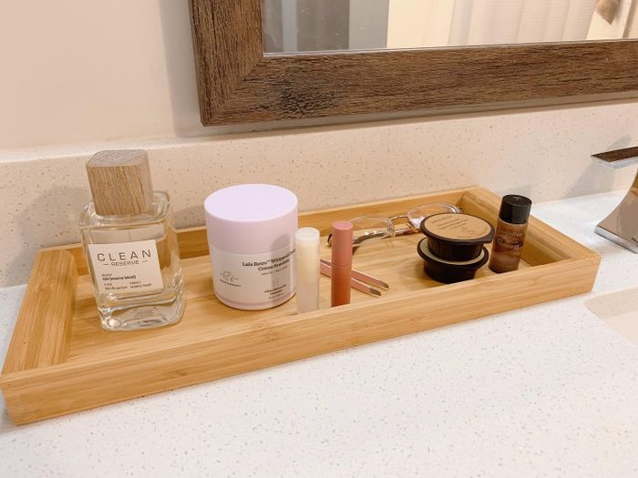 Another reviewer's bamboo tray on the bathroom counter, elegantly displaying perfumes and beauty products