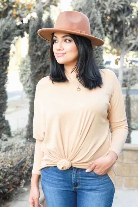 A reviewer wearing a beige long-sleeve shirt with a high neck.
